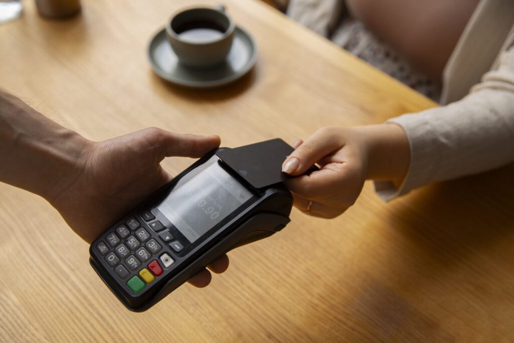 high-angle-customer-paying-with-nfc-device-min-scaled.jpg